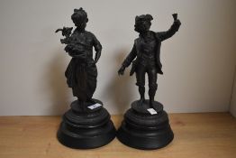 A pair of 19th/20th Century Continental spelter figural ornaments raised upon turned wooden bases of