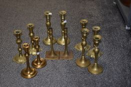 A pair of Georgian brass petal based candlesticks, fitted with a candle raising mechanism and