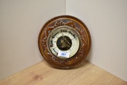 A late Victorian walnut cased aneroid barometer, with skeleton movement surrounded by enamelled dial