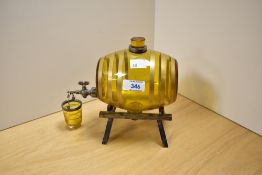 An Art Deco amber coloured glass whisky or brandy barrel and drip cup, of Asprey & Co. style, having