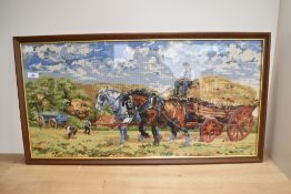 A 20th Century Continental needlework embroidery, depicting a harvest scene and displayed within a