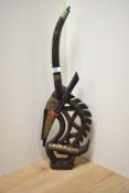 An African carved hardwood study of an antelope with gilt metal mounts, measuring 60cm high