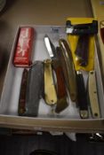 A Victorinox pocket multi-tool sold alongside a small assortment of pocket knives.