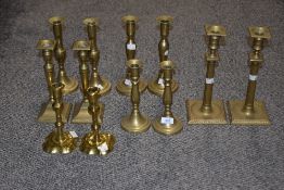 A pair of early 19th Century brass petal based candlesticks, measuring 18cm high, together with