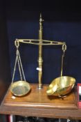 A set of late 19th/early 20th century brass scale with mahogany base.