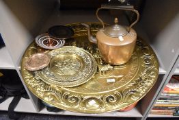 A large embossed brass decorative plaque, two smaller examples, small continental copper plates,