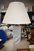 An attractive glass table lamp, of cylindrical form and decorated with white opaque swirls, 33cm