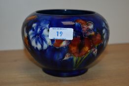 A Moorcroft bulbous shaped vase, decorated in the Orchid pattern against a cobalt blue ground,