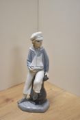 A Lladro porcelain figure boy with pond yacht, printed marks to underside 23cm