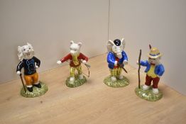 A group of four Royal Doulton bone china 'Rupert' figures, comprising Edward Trunk, pretending to be