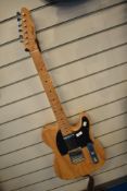 An Aiersi electric guitar , in the Fender Telecaster style with natural grain finish