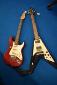 Two electric guitars, flying V and stratocaster style
