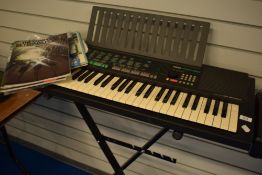 A Yamaha PSR -150 keyboard, stand and music books