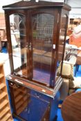 A reproduction Regency display cabinet with double cupboard under, of narrow proportions