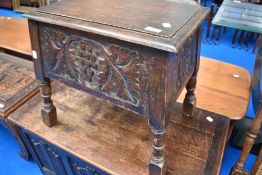An early 20th Century oak sewing box stool having carved vine decoration