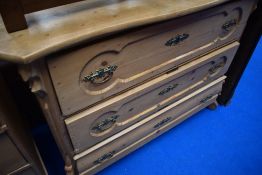 A 19th Century stripped pine chest of three long drawers having shaped top and scroll feet, width