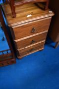 A modern pine three drawer bedside chest
