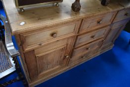 A stripped pine sideboard having central drawer section flanked by cupboards, width approx. 137cm
