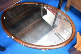 An Edwardian mahogany oval wall mirror