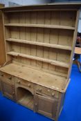 A traditional stripped pine dresser, approx. Dimensions W144 D42 H183cm