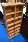 A modern golden oak narrow book/cassette shelf, dimensions approx. H113cm W48cm D17cm
