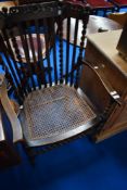 A late 19th or early 20th Century bergere cane seated carver chair having rail and barley twist back