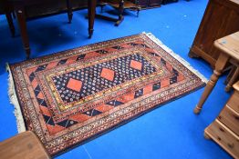 A vintage Chinese fireside rug having black and red ground
