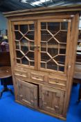 A 19th Century stripped bookcase having astragal glazed top over three drawers and lower panelled