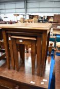 An early 20th Century mahogany nest of three tables on square tapered legs