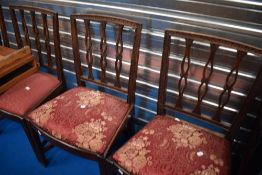 A set of four early 20th Century mahogany dining chairs having upholstered drop in seats
