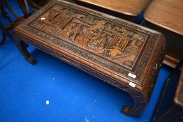 An Oriental coffee table having carved decoration and glass top, approx. 101 x 46cm