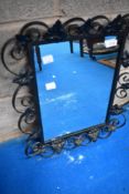 A decorative wall mirror having wrought frame