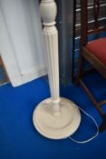 A painted standard lamp with shade