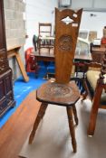 A traditional oak spinning chair having carved rosette decoration