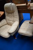 A faux leather easy chair and footstool