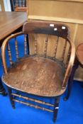 A late 19th or early 20th Century solid seat armchair having turned frame