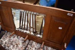 An Arts and Crafts style golden oak hall mirror with coat hooks