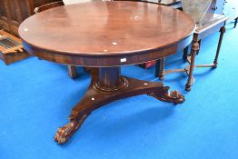 A 19th Century mahogany dining table having circular tilt top on William IV style trefoil base,