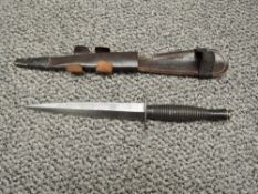 A British WWII Fairburn Sykes Commando Knife, blade length 17.5cm, overall length 29cm, with leather