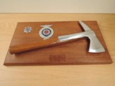 A Lancashire Fire and Rescue Service presentation Axe and Badge mounted on wooden plinth along