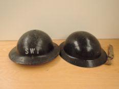 Two British WWII black Steel Helmets, one marked SWT and inside WD 1939, other dated inside 1941