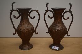 A pair of 19th/20th Century cast metal and twin handled vases, of Eastern design, each measuring