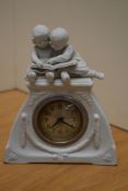 A 20th century Bisque porcelain figural mantel clock, depicting two young children reading a book to