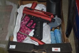 A Brawler paint ball gun, two CO2 canisters, a refill scoop and a quantity of purple paint balls.