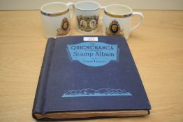 The Quickchange Illustrated Stamp Album (partially filled) and three Coronation ware mugs.