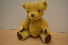 A Deans Childs Play Toys yellow plush Teddy Bear having plastic eyes and nose, stitched mouth and