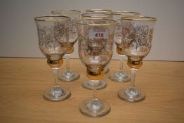 Seven wine glasses having gilt engraved leaf decoration.