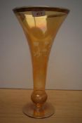 A vintage tinted glass vase of drawn trumpet form with basel knop, wheel engraved with foliate