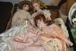 Four modern bisque headed dolls having material bodies.