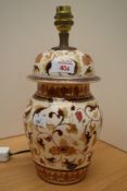 A decorative African pottery table lamp, of lidded urn form, hand decorated with repeating floral